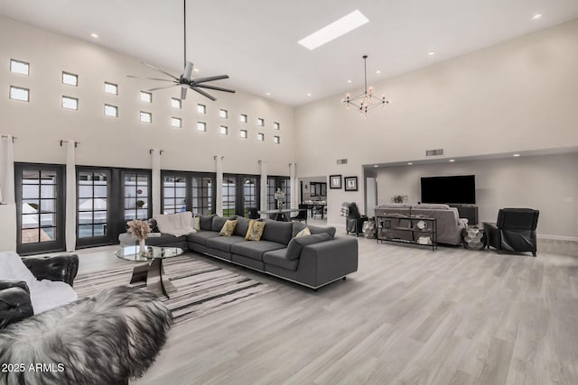 living area featuring light wood-style floors, visible vents, a skylight, and recessed lighting