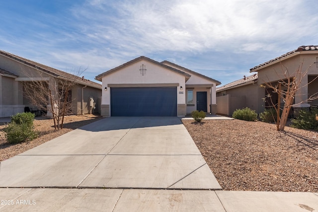 view of front of house featuring driveway, an attached garage, and stucco siding