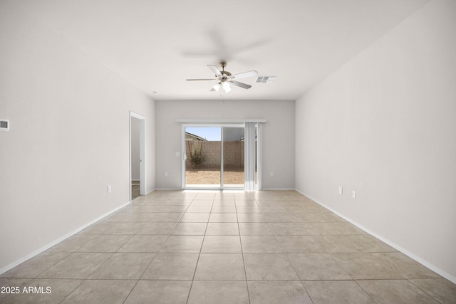 empty room with visible vents, light tile patterned floors, a ceiling fan, and baseboards