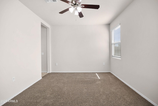 carpeted empty room featuring ceiling fan, visible vents, and baseboards