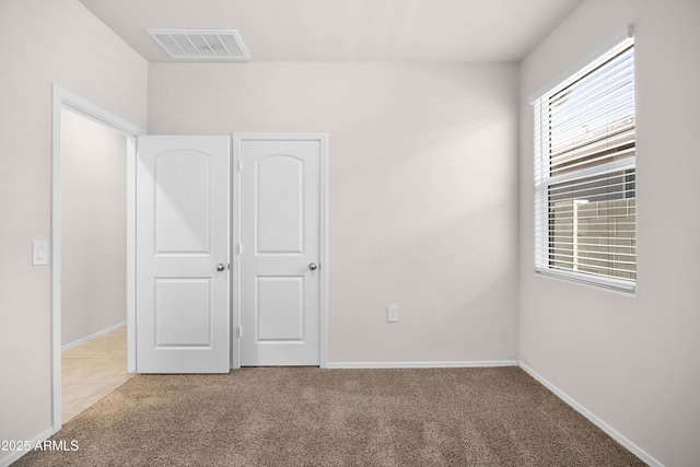 unfurnished bedroom with light carpet, baseboards, and visible vents