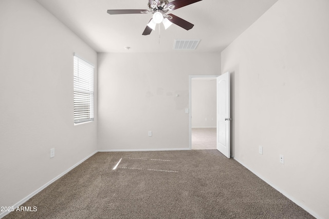 carpeted empty room with a ceiling fan, visible vents, and baseboards