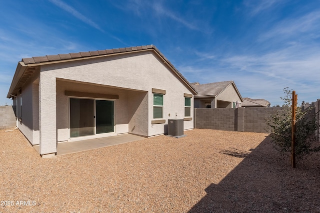 rear view of house with fence private yard, cooling unit, a tiled roof, stucco siding, and a patio area