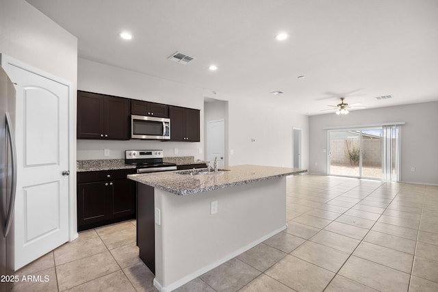 kitchen with a center island with sink, visible vents, open floor plan, stainless steel appliances, and a sink