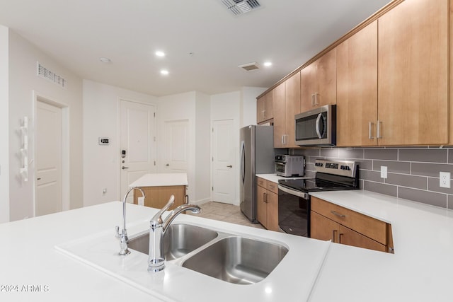 kitchen with sink, appliances with stainless steel finishes, and tasteful backsplash