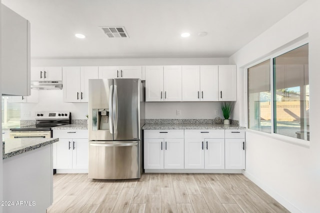 kitchen with light stone countertops, stainless steel appliances, white cabinetry, and light hardwood / wood-style flooring