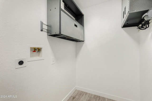 clothes washing area with hookup for a washing machine, light hardwood / wood-style flooring, and hookup for an electric dryer