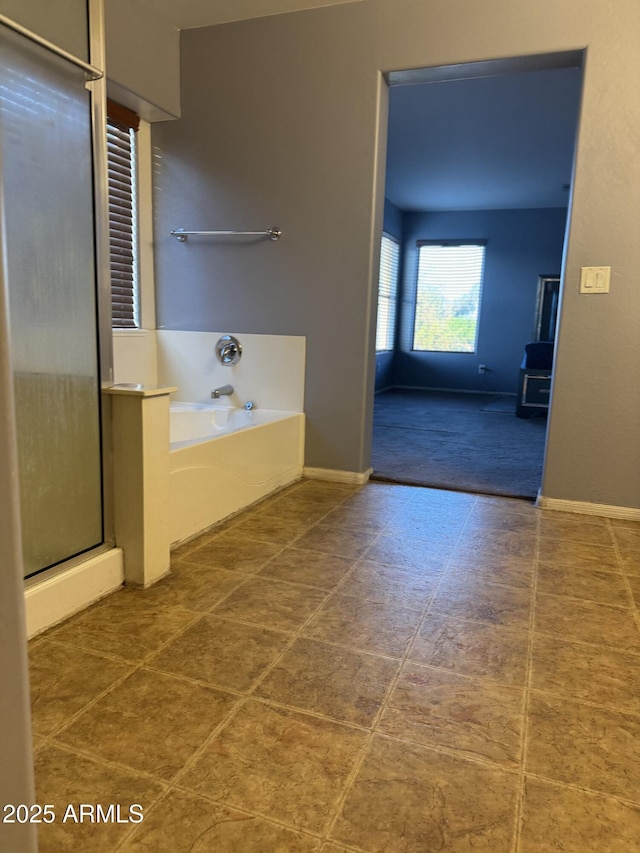 9108 W Kirby Ave, Tolleson, AZ 85353 - full bath featuring a shower stall, baseboards, and a garden tub