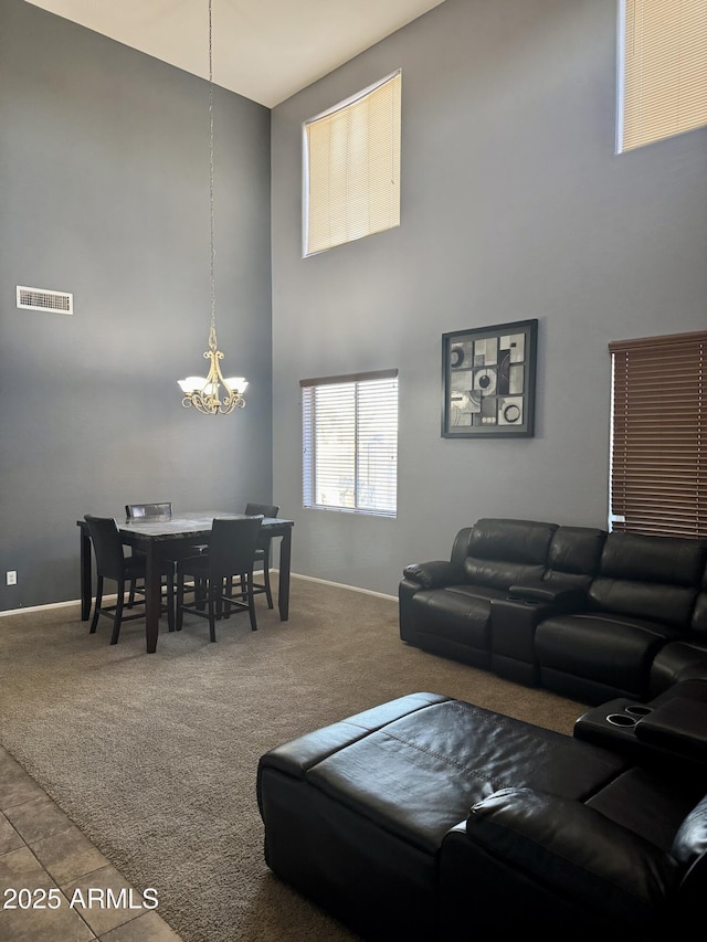 9108 W Kirby Ave, Tolleson, AZ 85353 - carpeted living area with baseboards, a high ceiling, a notable chandelier, and visible vents
