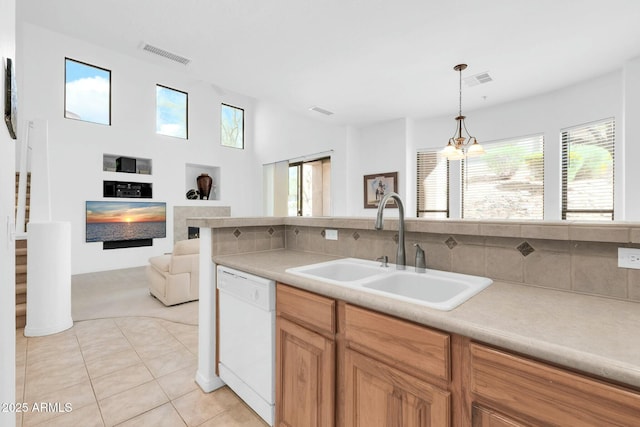 kitchen featuring visible vents, open floor plan, white dishwasher, light countertops, and a sink