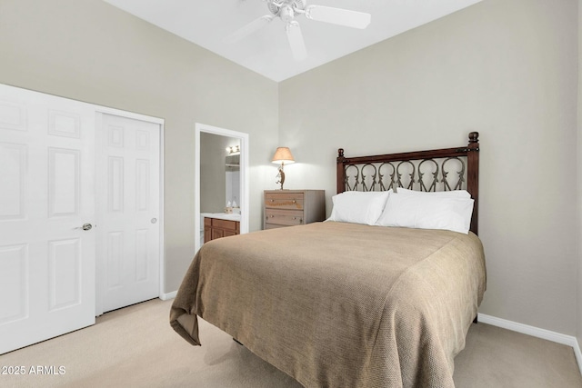 bedroom featuring light carpet, ensuite bath, baseboards, and ceiling fan