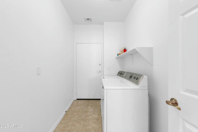 washroom with light tile patterned floors, laundry area, visible vents, baseboards, and washer and dryer