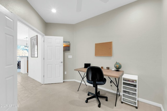 home office with a ceiling fan, light carpet, and baseboards