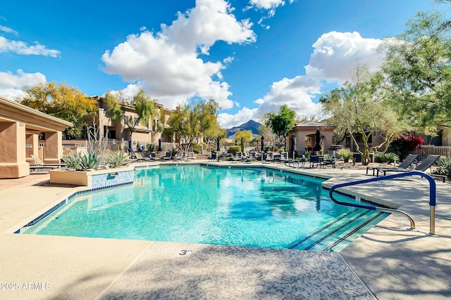 pool with a patio area and fence