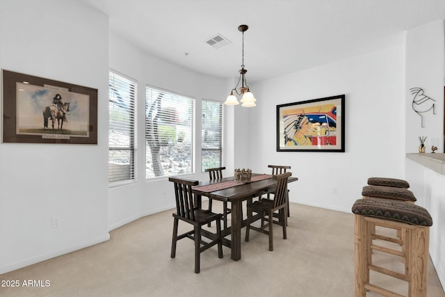 dining room featuring light carpet, visible vents, and baseboards