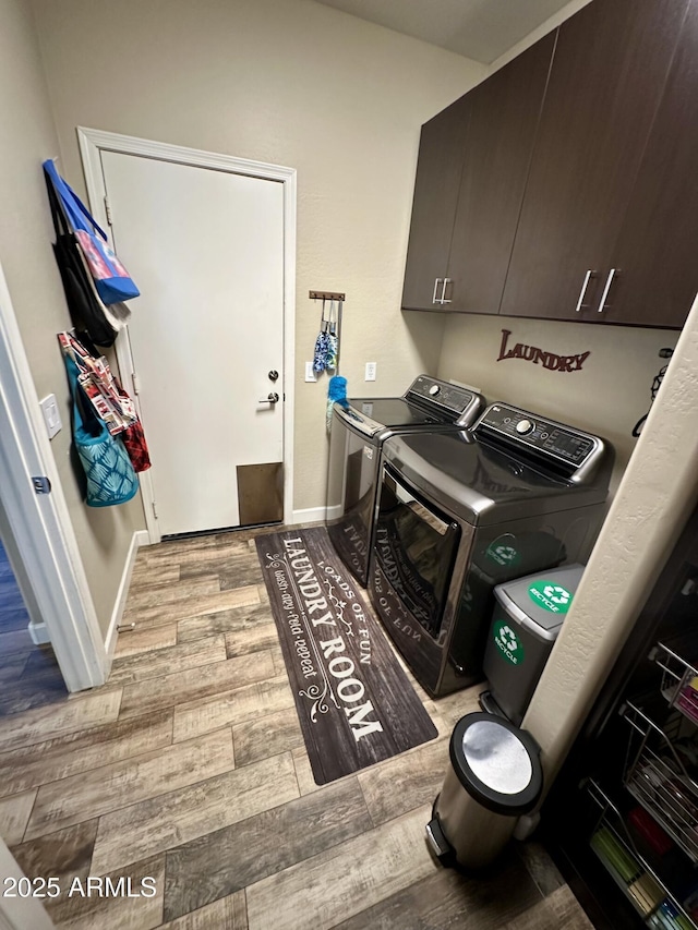 laundry room with washer and dryer, baseboards, wood finished floors, and cabinet space