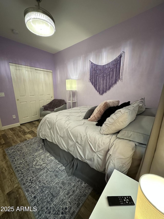 bedroom featuring a closet, baseboards, and wood finished floors