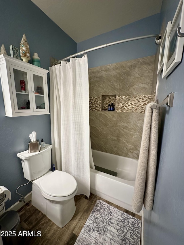 bathroom with shower / bathtub combination with curtain, baseboards, toilet, and wood finished floors