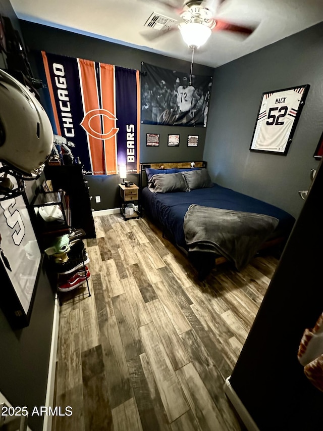 bedroom featuring visible vents, ceiling fan, and wood finished floors