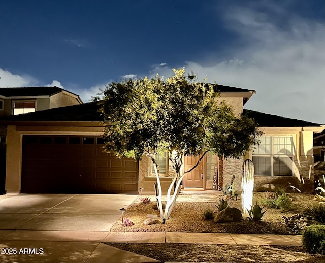 obstructed view of property featuring an attached garage, driveway, and stucco siding
