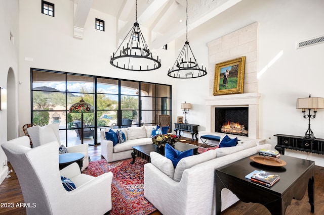 living room with beamed ceiling, dark wood-type flooring, a high ceiling, and a tile fireplace