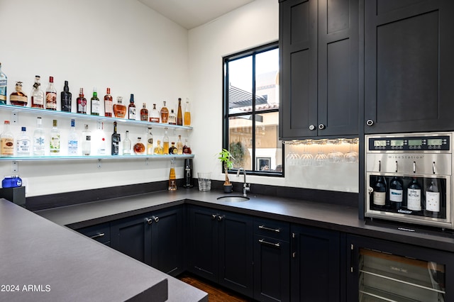 bar featuring dark hardwood / wood-style floors, oven, and sink