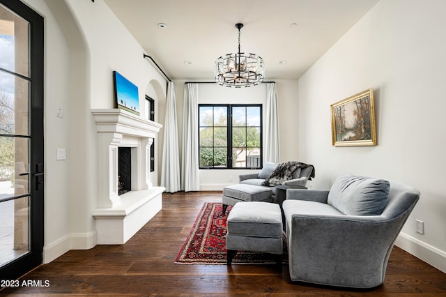 living room featuring a notable chandelier and dark wood-type flooring