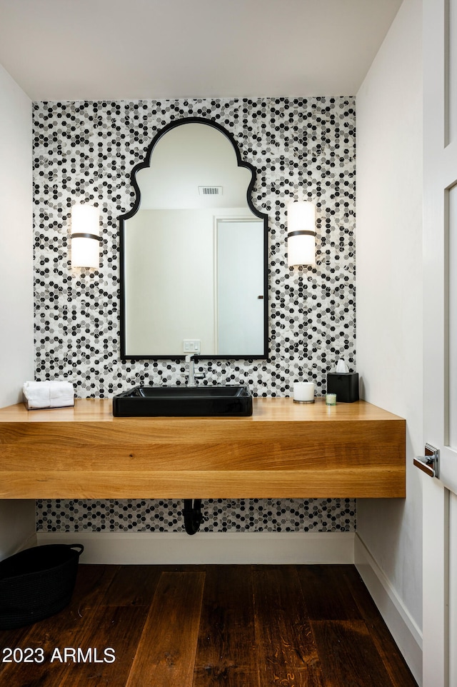 interior space featuring wood-type flooring, backsplash, and vanity