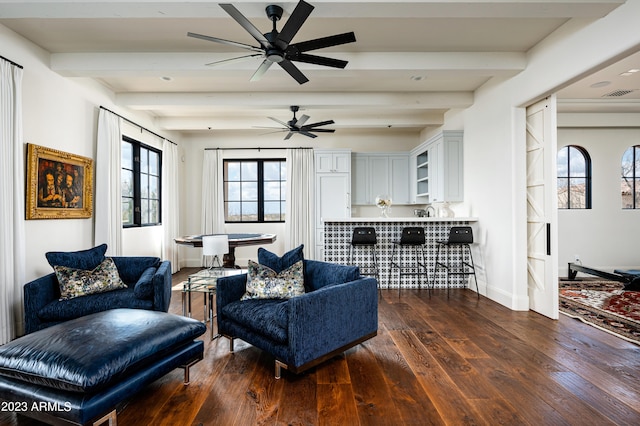 living room featuring beam ceiling, a healthy amount of sunlight, and dark hardwood / wood-style flooring