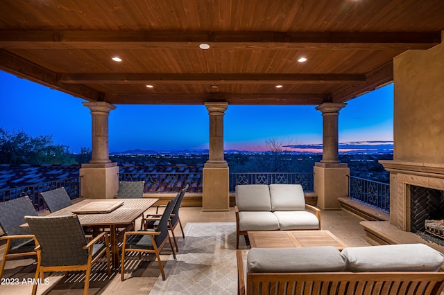 patio terrace at dusk with an outdoor living space with a fireplace