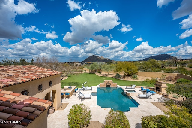 view of pool with a patio, a mountain view, an in ground hot tub, and a yard