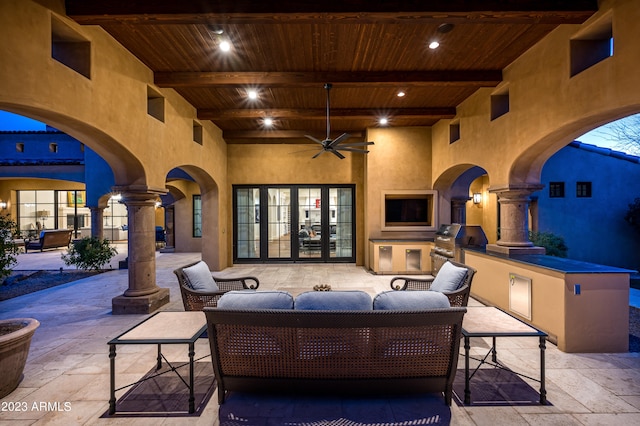 view of patio with ceiling fan and an outdoor living space with a fireplace