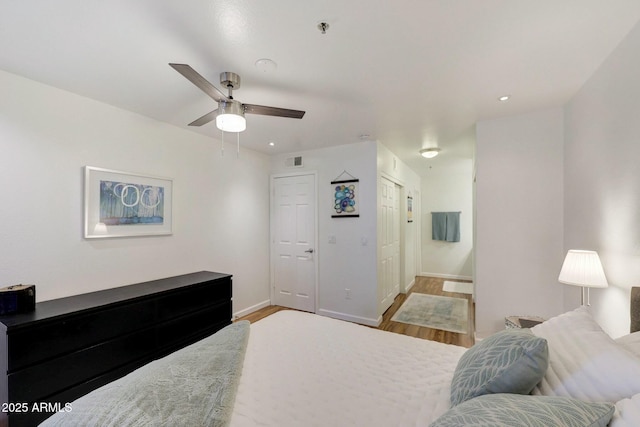 bedroom featuring baseboards, visible vents, wood finished floors, and recessed lighting