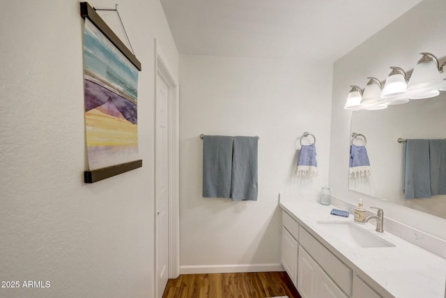 bathroom with vanity, baseboards, and wood finished floors