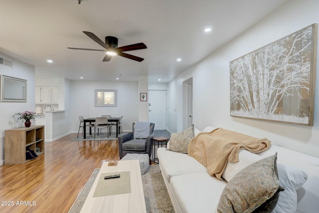 living area with light wood finished floors, visible vents, baseboards, ceiling fan, and recessed lighting