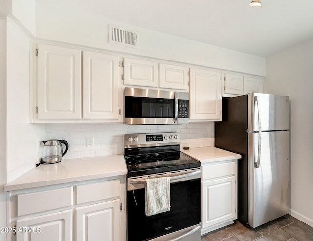 kitchen with white cabinets, visible vents, stainless steel appliances, and backsplash