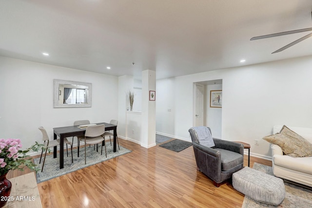 living room with baseboards, light wood-type flooring, a ceiling fan, and recessed lighting