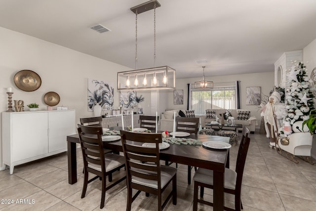 dining space featuring light tile patterned floors and an inviting chandelier