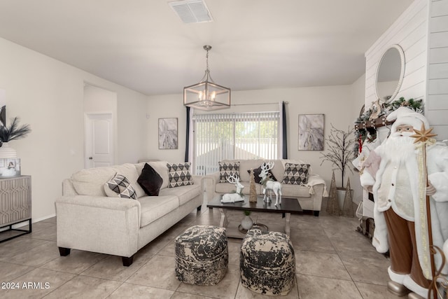 living room with a chandelier and light tile patterned flooring