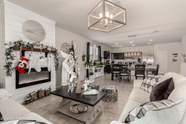 tiled living room with a fireplace and a chandelier