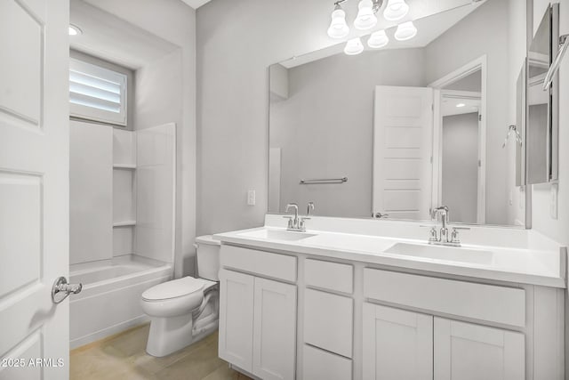 bathroom with double vanity, shower / bathing tub combination, a sink, and toilet