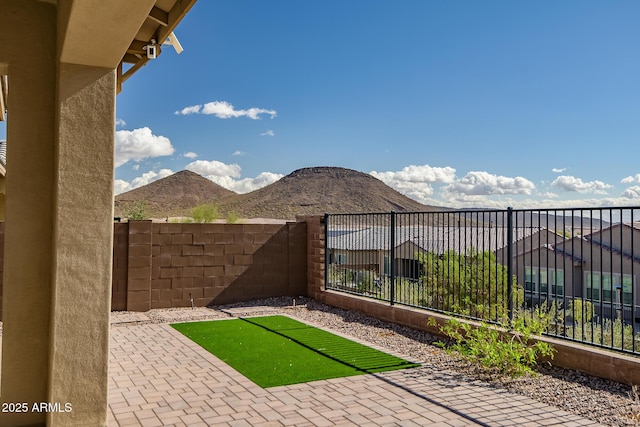 view of yard with a patio area, fence, and a mountain view