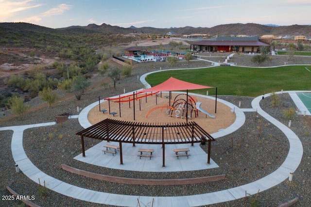 view of home's community featuring playground community, a yard, and a mountain view