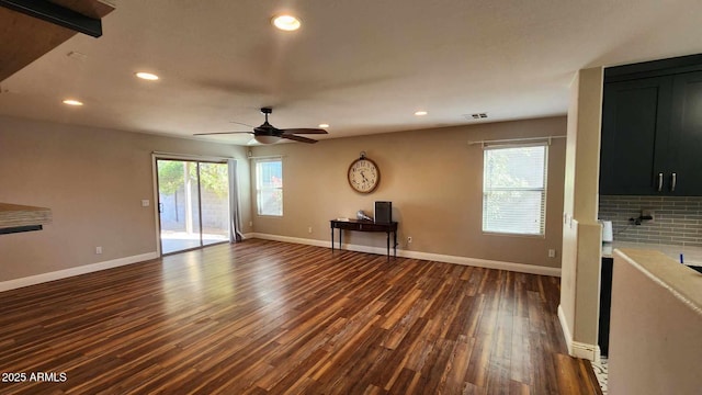 unfurnished living room featuring ceiling fan and dark hardwood / wood-style flooring