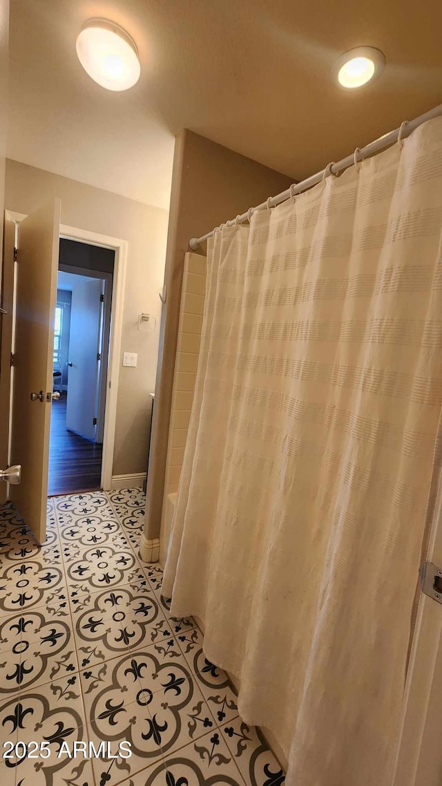 bathroom with tile patterned floors and shower / bathtub combination with curtain