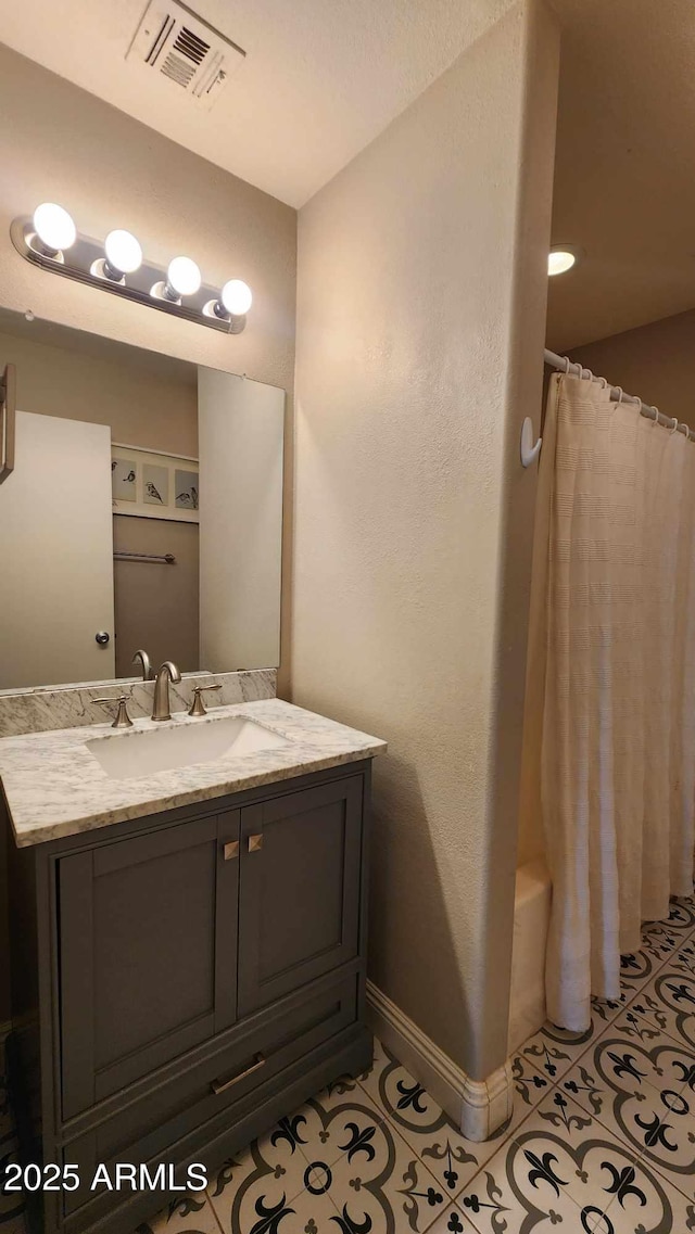 bathroom featuring tile patterned flooring, vanity, and shower / tub combo with curtain