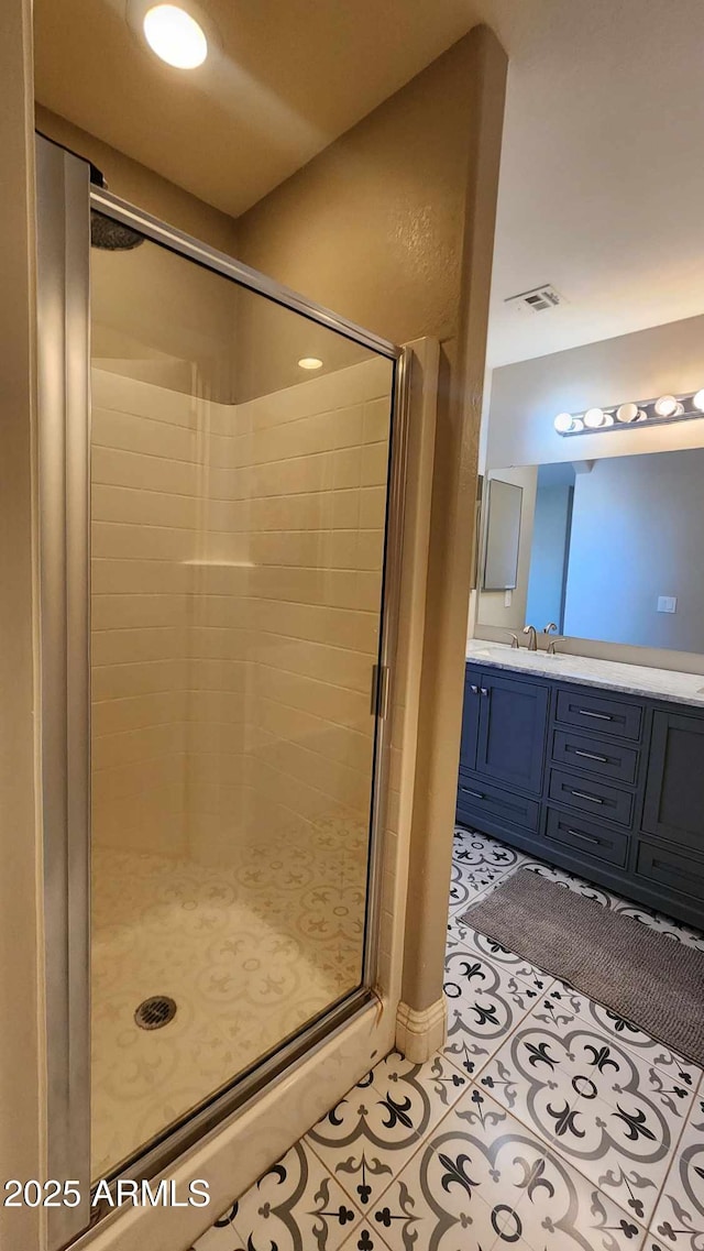 bathroom with tile patterned flooring, vanity, and a shower with shower door