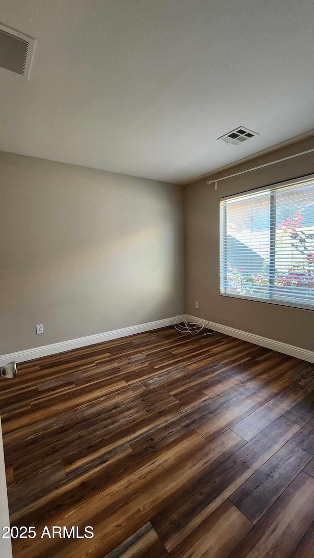 unfurnished room with dark wood-type flooring