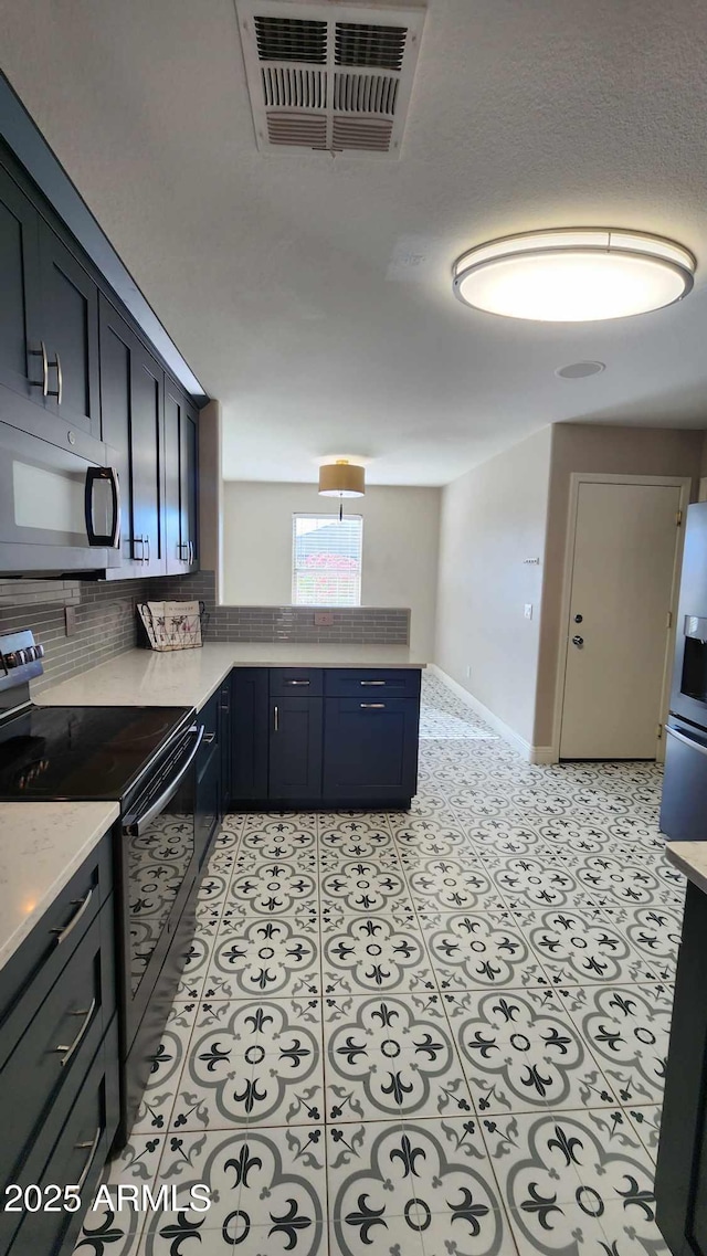 kitchen with tasteful backsplash, light tile patterned floors, and appliances with stainless steel finishes