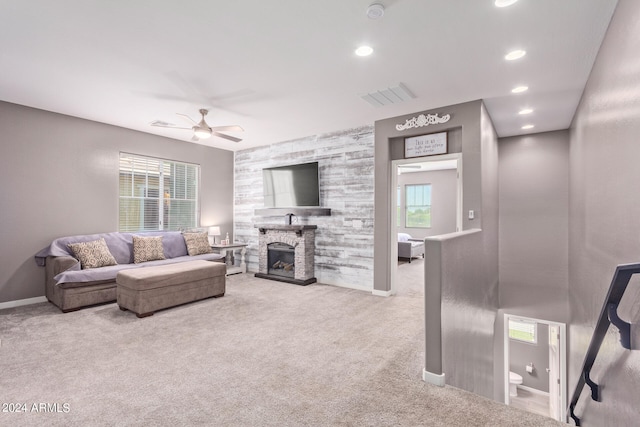 living room with carpet, a fireplace, and ceiling fan